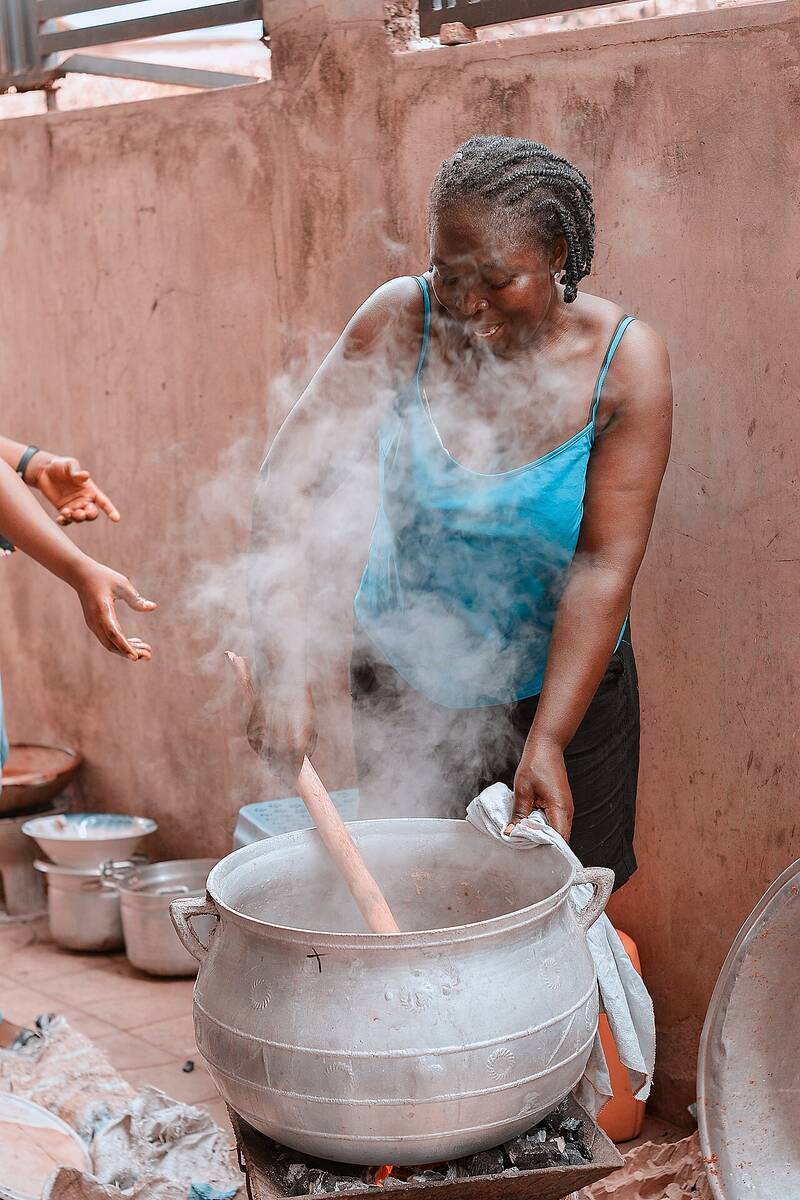A cook stirring nshima in a large pot