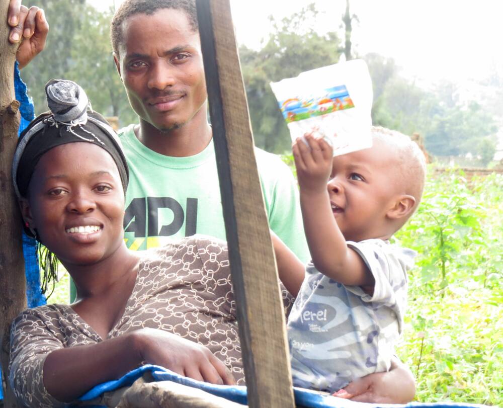 A smiling Lusaka-area family with their happy toddler