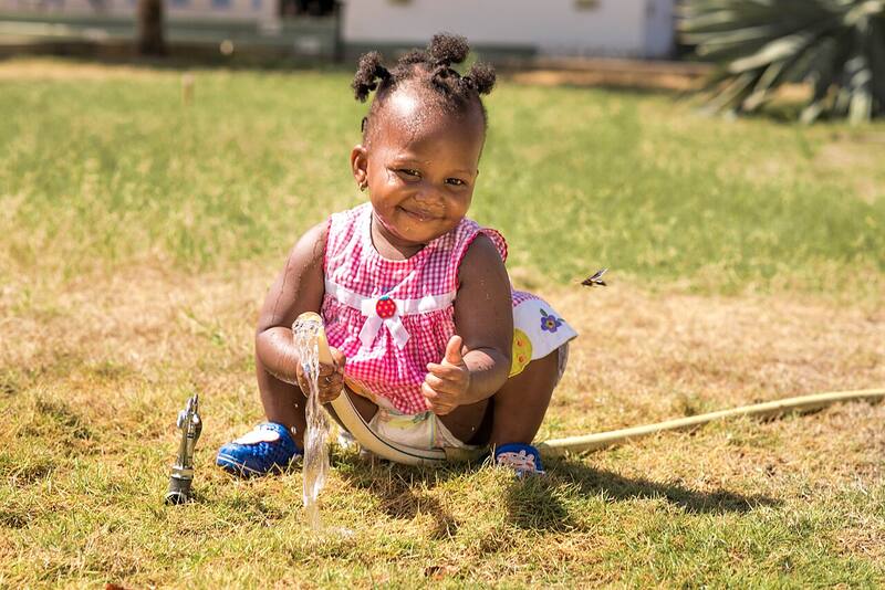 A happy toddler playing in a sunny garden